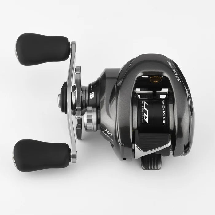 Eine Nahaufnahme von oben einer Gomexus Flat Spool BFS Spule Aluminium für Shimano 20 & 22 Metanium Rollen, mit zwei schwarzen Griffen und Einstellknöpfen, mit sichtbarem Branding auf einem schlichten weißen Hintergrund.