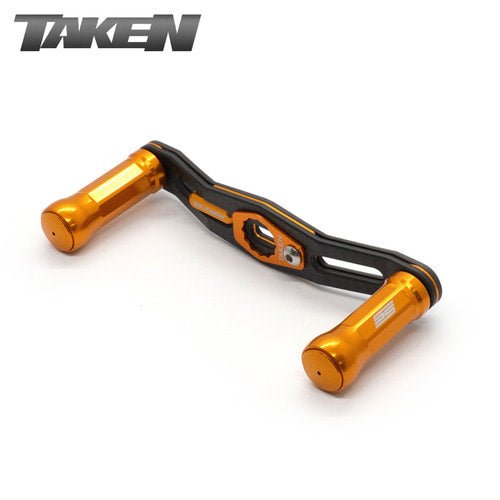 Der Taken SS Carbon Handle 90mm verfügt über orangefarbene SS-Aluminiumknöpfe und einen Carbonrahmen, der mit Shimano- und Daiwa-Rollen kompatibel ist - ideal für Finesse und ultraleichte Baitcaster-Setups. Mit dem Taken-Logo auf weißem Hintergrund dargestellt.
