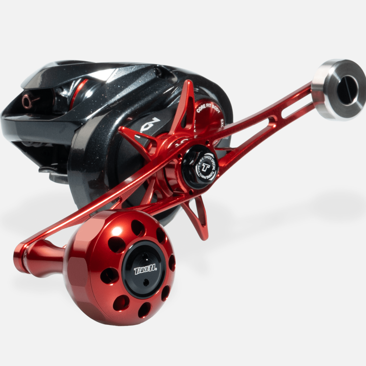 Eine Nahaufnahme des Taken X3 Knob 50mm Power Tuning Griffs für Shimano & Daiwa Rollen, mit einem schwarzen Metallgehäuse und einem großen rot eloxierten Aluminiumknauf - perfekt für Hecht & Bigbait Angler.