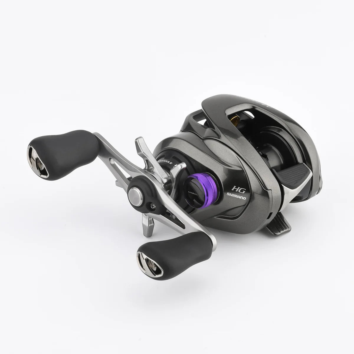 Nahaufnahme einer Shimano-Baitcasting-Rolle mit schwarzen und silbernen Teilen, mit einer violetten Gomexus-Aluminium-Spannknopfkappe für 20/22/23-Metanium-Rollen, zwei Griffen mit Griffen und HG-Branding auf weißem Hintergrund.