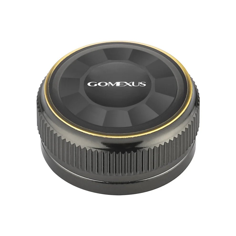 Die Gomexus Aluminum Spool Tension Knob Cap für 20, 22 und 23 Metanium Shimano Baitcaster ist rund und schwarz mit einem Metallic-Finish, geriffelten Seiten für mehr Griffigkeit, einem goldenen Ring am Rand und dem Aufdruck "Gomexus" in Weiß auf der Oberseite.