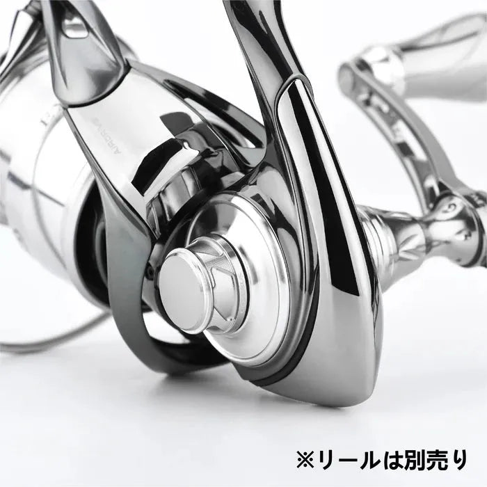 Nahaufnahme der Gomexus Griff-Schraubkappe für Daiwa- und Shimano-Rollen mit glänzendem, metallischem Design und gebogenen Kurbelarm-Kappen aus Aluminium. Japanischer Text unten rechts: ※リールは別売り (Rolle separat erhältlich). Marke: Gomexus.