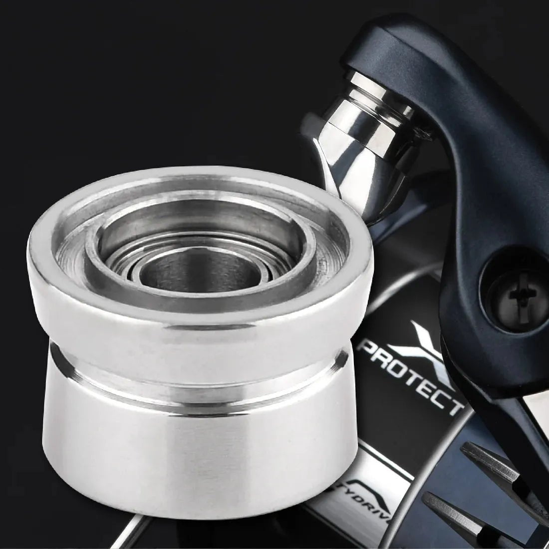 Nahaufnahme eines silbernen Gomexus Schnurlaufröllchens für Shimano SW Angelrollen, vor einer teilweise sichtbaren dunklen Angelrolle mit der Aufschrift „PROTECT“, die den Spulenteil und die detaillierten Gomexus-Rollenkomponenten hervorhebt.