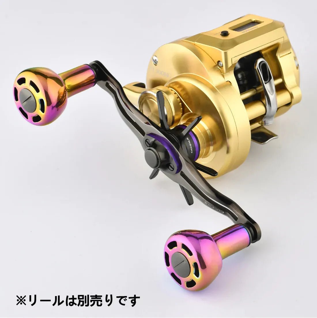 Eine Nahaufnahme eines metallischen Rollengriffs mit dem Gomexus Titanium Power Knob 30 mm TA30 in Regenbogenfarben, befestigt an einer goldenen Rolle. Der japanische Text lautet: ※リールは別売りです (Die Rolle ist separat erhältlich). Marke: Gomexus.