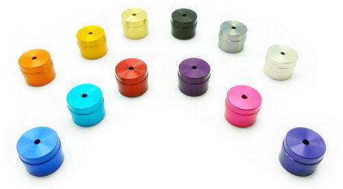 Zwölf Hedgehog Studio Knob Caps für Daiwa I-Shape in Farben wie Blau, Rot, Gold, Silber, Lila und Schwarz sind in einem lockeren Bogen auf weißem Hintergrund angeordnet. Jede Kappe zeigt eine einzigartige Farbe von Hedgehog Studio.