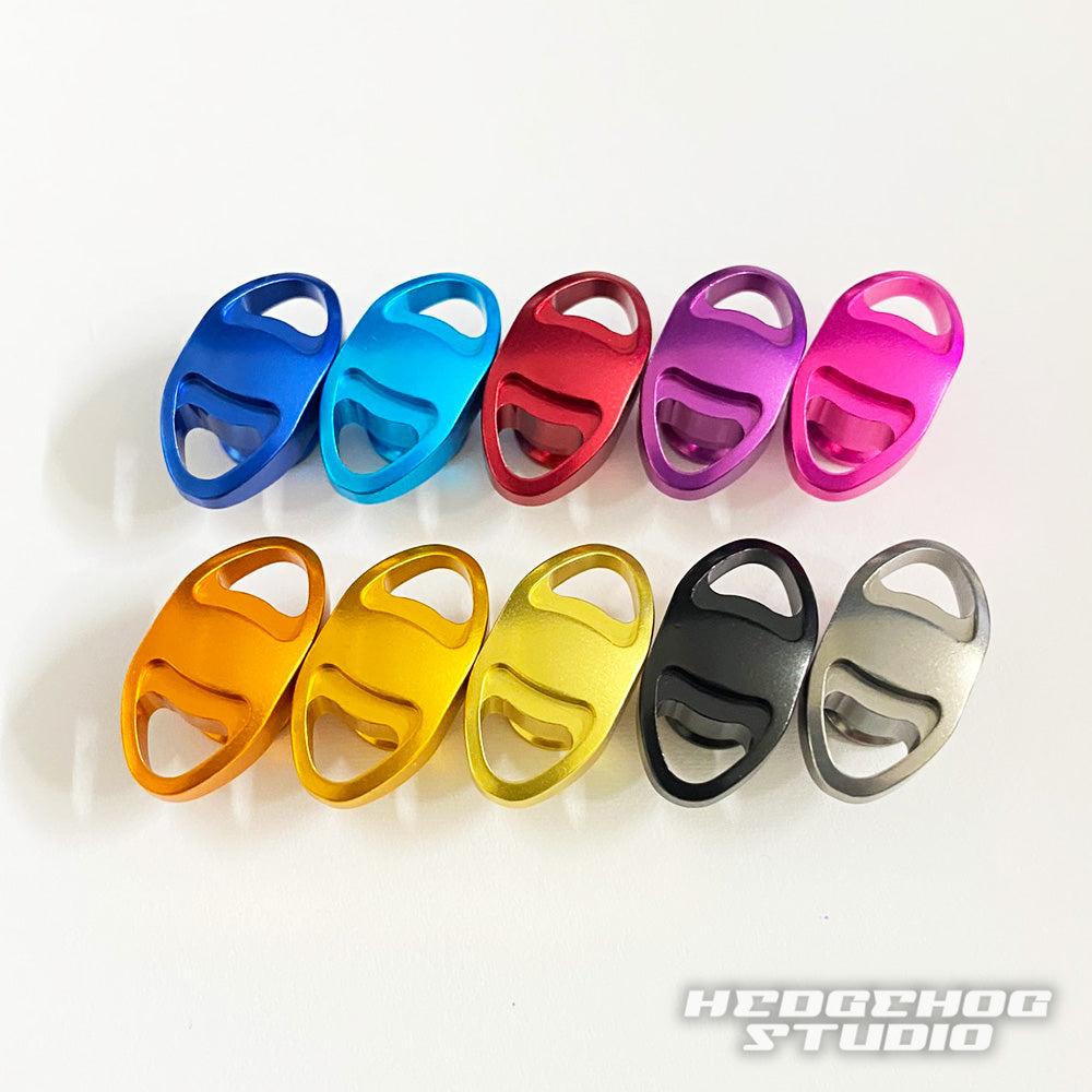 Zehn ovale Hedgehog Studio-Knopfkappen aus Metall für Shimano 20 Metanium, 22 Metanium Shallow Edition und 20 SLX DC in verschiedenen Farben werden in Reihen auf weißem Grund angezeigt. „HEDGEHOG STUDIO“ ist unten rechts abgebildet.