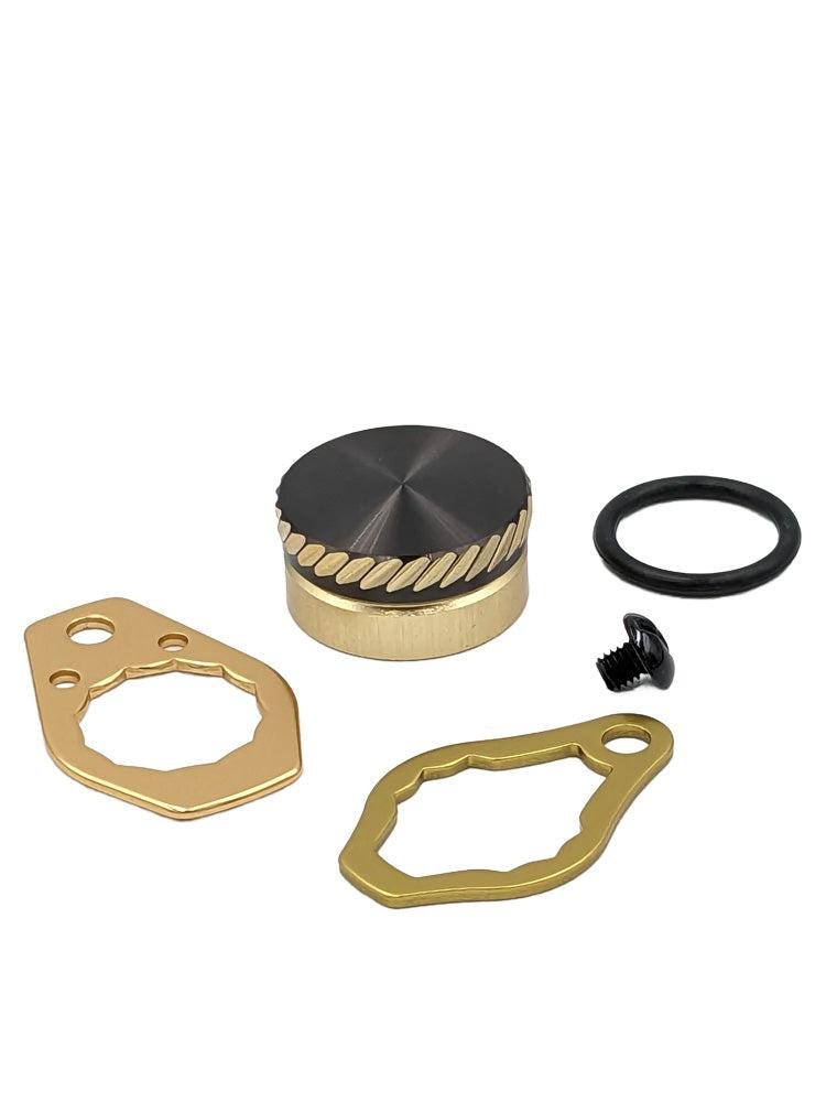 Das SLP Works MC Zero Adjuster Set von SLP Works besteht aus einem Metallknopf mit strukturierter Kante, einer schwarzen Schraube, einem schwarzen O-Ring und zwei goldfarbenen Platten mit einzigartigen Aussparungen auf weißem Hintergrund.