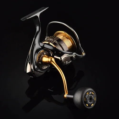 Eine Nahaufnahme des Gomexus Carbon Power Knob 38 mm von Gomexus, einem modernen Zubehör für Angelrollen in Metallic-Gold und Schwarz, präsentiert vor einem einfarbig schwarzen Hintergrund.