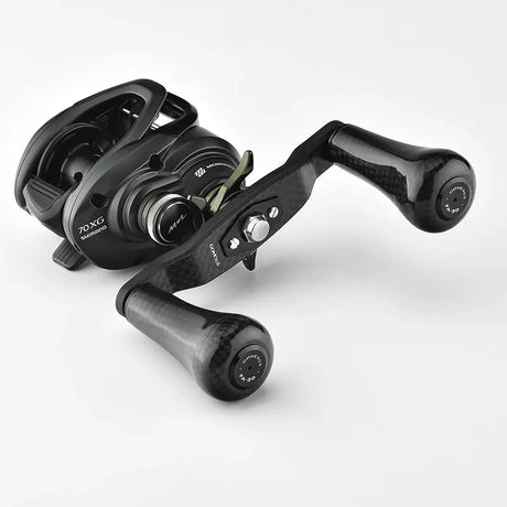 Eine schwarze Baitcastingrolle mit einem Gomexus Carbon 98 mm Griff mit 30 mm Carbonknöpfen, Metallteilen und Einstellknöpfen von Gomexus ist vor einem schlichten weißen Hintergrund abgebildet.