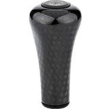 Der Gomexus FA30 Carbon Knob von Gomexus ist ein schwarzer Schaltknauf aus Toray-Kohlefaser mit strukturiertem, gewebtem Muster und abgerundeter Oberseite mit Text und Symbolen für die Gangpositionen.