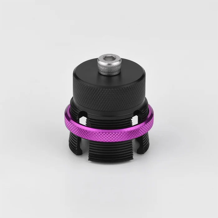 Die Gomexus Flat Spool für Shimano 20 & 22 Metanium, eine schwarze Aluminium-BFS-Spule mit einem gerändelten lila Ring und einem silbernen Bolzen, wird vor einem schlichten weißen Hintergrund gezeigt.