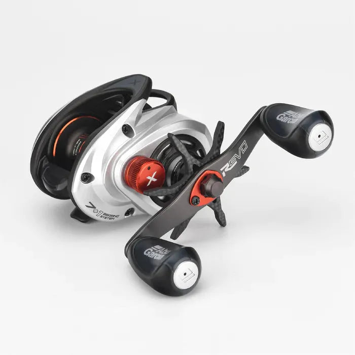Eine Nahaufnahme der Gomexus Sternbremse Carbon 60-mm-Rolle für Abu Garcia mit silberner und schwarzer Carbonkonstruktion, roten Akzenten, zwei Kurbelknöpfen und Markenmarkierungen vor einem schlichten weißen Hintergrund.