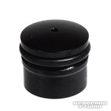 Eine kleine, schwarze, zylindrische Daiwa Zaion-Knopfkappe von Hedgehog Studio mit zwei Rillen oben und einem winzigen Loch in der Mitte; in der unteren rechten Ecke befindet sich das Wasserzeichen „HEDGEHOG STUDIO“.