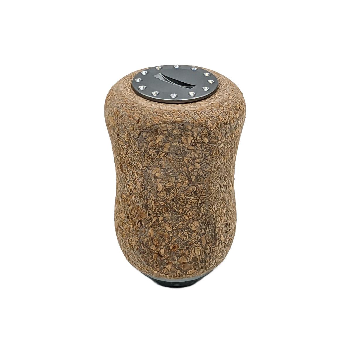 Der RL-TNG Kork Knob 20 mm von RL-Angelrollentuning ist ein zylindrischer Korkgriff mit einer schwarzen Oberseite mit weißen Markierungen, der für eine universelle Passform konzipiert ist – ideal, um Ihrer Angelrolle einen einzigartigen Stil zu verleihen.