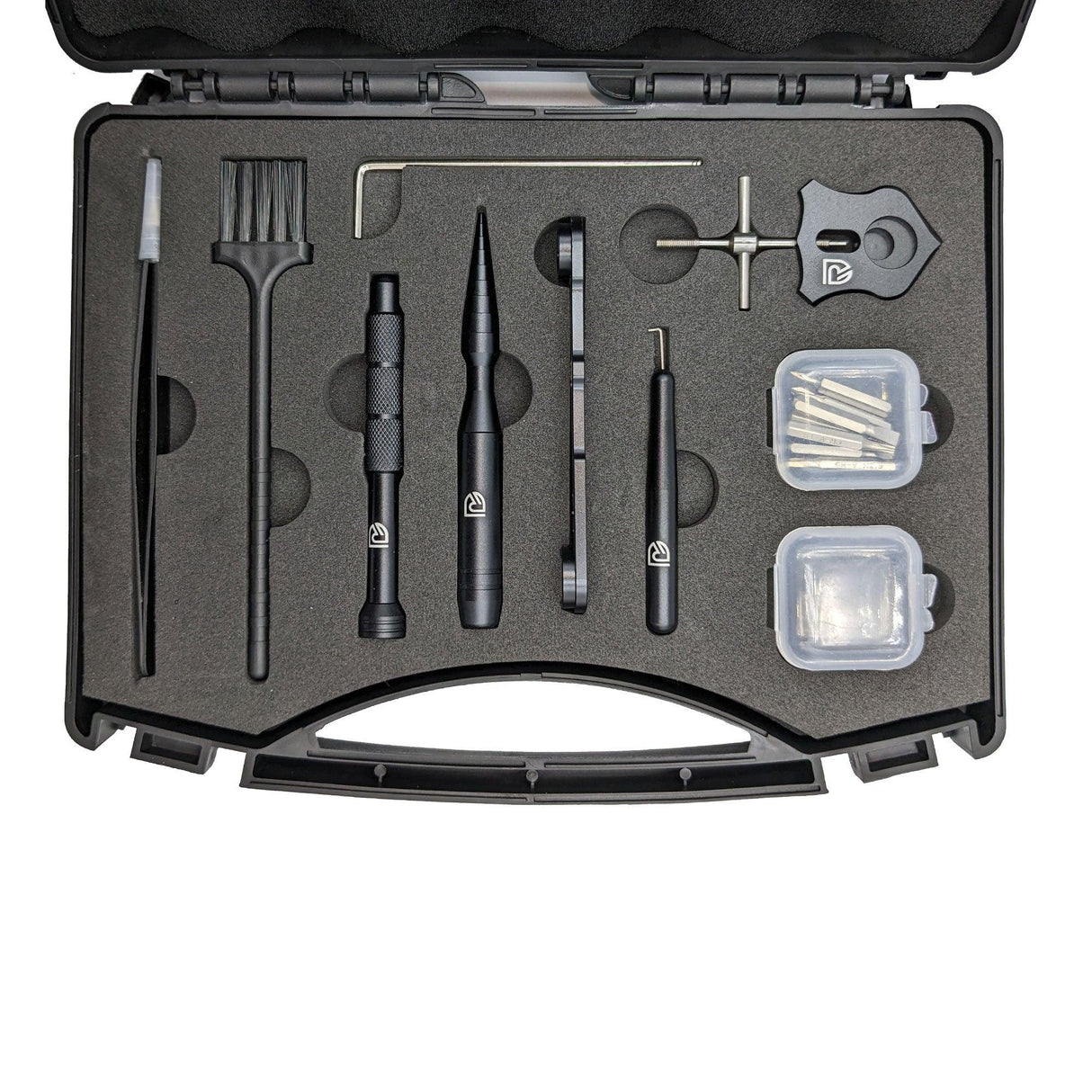 Das RL-TNG Wartungskit Werkzeugkoffer für Baitcaster-Angelrollen von RL-Angelrollentuning umfasst Bürste, Werkzeuge, Schraubenschlüssel und Behälter – alles ordentlich organisiert in einem schwarzen Schaumstoffkoffer, ideal für die Rollenwartung.