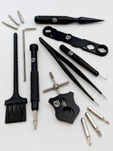 Das RL-TNG Wartungskit von RL-Angelrollentuning umfasst schwarze und silberne Präzisionsschraubendreher, Schraubenschlüssel, Pinzette, Bürste, Sechskantbits und Multitool – idealer Werkzeugkoffer für Baitcaster Angelrollen, alle mit passendem Logo.