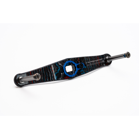 Eine Nahaufnahme des Rollenwerk Custom Carbon Griffs (Baitcaster-Kurbel, Nebula), die die gemusterte Oberfläche und das blaue sechseckige Zentrum zeigt - in Deutschland mit einer Präzision gefertigt, die an High-End Skate- oder Longboard-Teile erinnert.