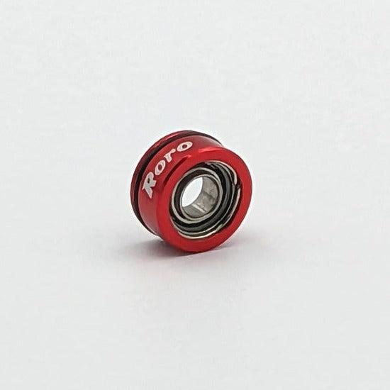 Ein kleiner roter Roro-Köder aus Metall von BFS Keramik Kugellager mit "Roro" in weißer Schrift auf dem Rand, abgebildet auf einem schlichten weißen Hintergrund.