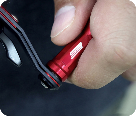 Nahaufnahme einer Hand, die ein rotes Metallwerkzeug mit weißer SS-Schrift hält und ein schwarz-rotes mechanisches Bauteil einstellt oder dreht. Der Hintergrund ist unscharf.