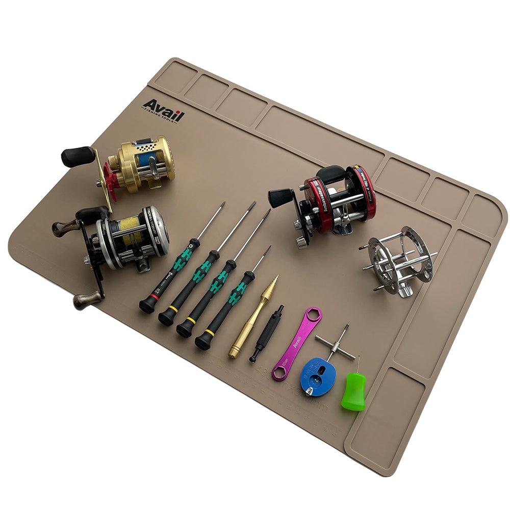 Avail Wartungsmatte in Beige: Zeigt vier Baitcaster-Rollen, fünf Präzisions-Schraubendreher, ein goldenes Spezial-Tool, zwei farbige Schlüssel (pink und blau), ein grünes Reel-Tuning-Teil plus Kleinteile – alles für dein einfaches Baitcaster-Tuning stilvoll sortiert.