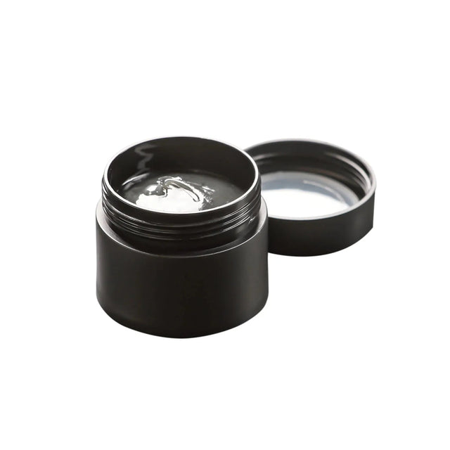 Ein schwarzes Glas mit offenem Deckel enthält Glitch Oil Premium Materia Grease Nr. 305 von Glitch Oil Japan, ein klares Hochleistungsfett für die Rollenpflege. Das Glas ohne Beschriftung steht auf weißem Untergrund und weist keine sichtbaren Etiketten oder Markierungen auf.