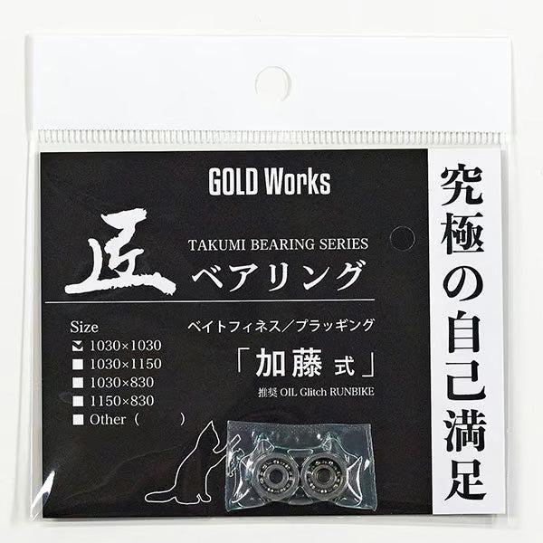 Eine schwarz-weiße Packung mit der Aufschrift Gold Works Takumi Kugellager 1030 x 830 von Gold Works enthält zwei hochwertige Kugellager für die Köderfinesse und das Rollentuning in einem durchsichtigen Beutel, der eine Katzensilhouette, eine Größentabelle und japanischen Text auf der Verpackung zeigt.