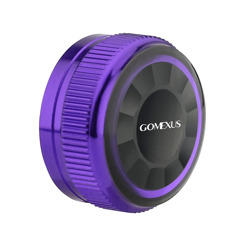Eine runde, lilafarbene und schwarze Gomexus-Aluminiumkappe für den Spulenspannungsknopf mit geriffelter Kante und der Aufschrift "GOMEXUS Spool Tension Knob" in Weiß, entworfen für Shimano 20/22/23 Metanium Baitcaster.