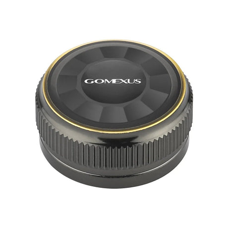 Die Gomexus Aluminum Spool Tension Knob Cap für 20, 22 und 23 Metanium Shimano Baitcaster ist rund und schwarz mit einem Metallic-Finish, geriffelten Seiten für mehr Griffigkeit, einem goldenen Ring am Rand und dem Aufdruck "Gomexus" in Weiß auf der Oberseite.