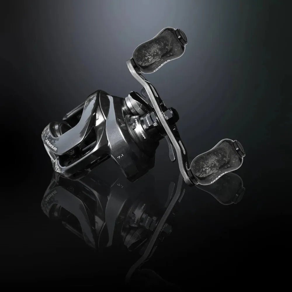 Eine Nahaufnahme eines Gomexus Carbon Forged F22 Knopfes von Gomexus mit dunklem Carbon-Finish und Edelstahlkugellager, dargestellt auf einer reflektierenden schwarzen Oberfläche vor einem schwarz-grauen Hintergrund mit Farbverlauf.