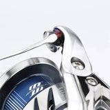 Nahaufnahme eines Gomexus Schnurlaufröllchens für Shimano Angelrollen, die den Griffansatz und einen Teil der Spule zeigt. Modernes blau-silbernes Design mit "Infinity Xross" Text auf der Spule. Marke: Gomexus.