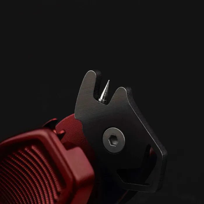 Nahaufnahme des Gomexus SharkBite Schnurknipser Combo von Gomexus, die den scharfen Edelstahlklingen-Spike und den Sechskantbolzen vor einem dunklen Hintergrund zeigt.