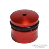 Eine kleine, zylindrische, rote Hedgehog Studio Knob Cap (Daiwa Zaion) mit einem schwarzen Gummi-O-Ring im oberen Bereich und einem zentralen Loch auf der flachen Oberseite. Das Foto zeigt unten rechts ein Wasserzeichen von Hedgehog Studio.