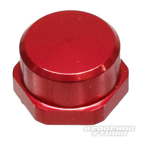 Auf weißem Untergrund ist eine rote, sechseckige Hedgehog Studio Shimano Griff-Kontermutter M7 für originale Shimano Kurbeln mit glatter, flacher Oberseite abgebildet. In der unteren rechten Ecke steht „HEDGEHOG STUDIO“.