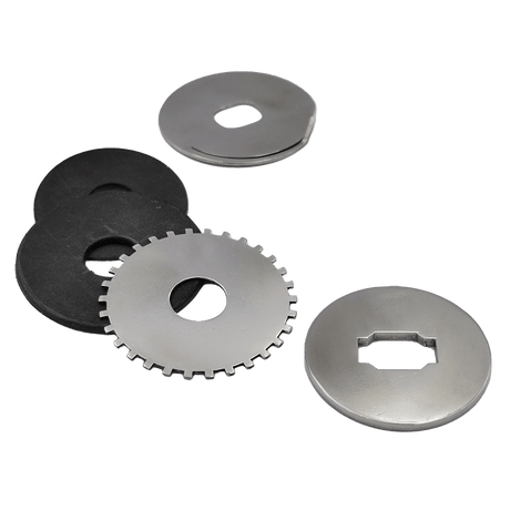 Vier Metallscheiben und zwei schwarze Gummi-Eisscheiben aus dem Dragclicker | Baitcaster | Daiwa-Set von Reset Reels sind auf weißem Hintergrund angeordnet. Die Metallscheiben verfügen über gezahnte Kanten und geometrische Aussparungen für optimale Bremsleistung.