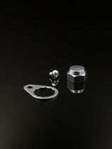 Eine RL-Angelrollentuning Kontermutter inkl. Plättchen M7 in Silber, samt flacher Metallplatte und Sechskant-Kontermutter, werden auf einer reflektierenden schwarzen Fläche dargestellt.