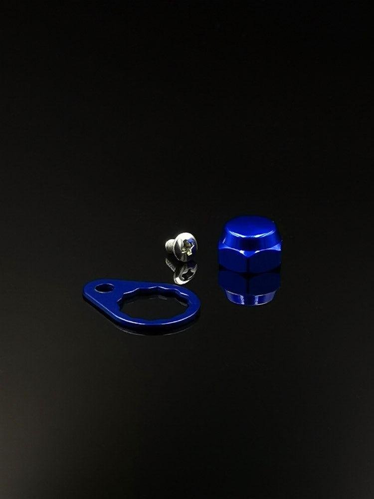 Die Kontermutter inkl. Teller (M7, verschiedene Farben) von RL-Angelrollentuning wird mit einer blauen Sechskantkappe aus Metall, einem passenden Ring mit Loch und einer kleinen silbernen Schraube auf schwarzem Hintergrund angezeigt.