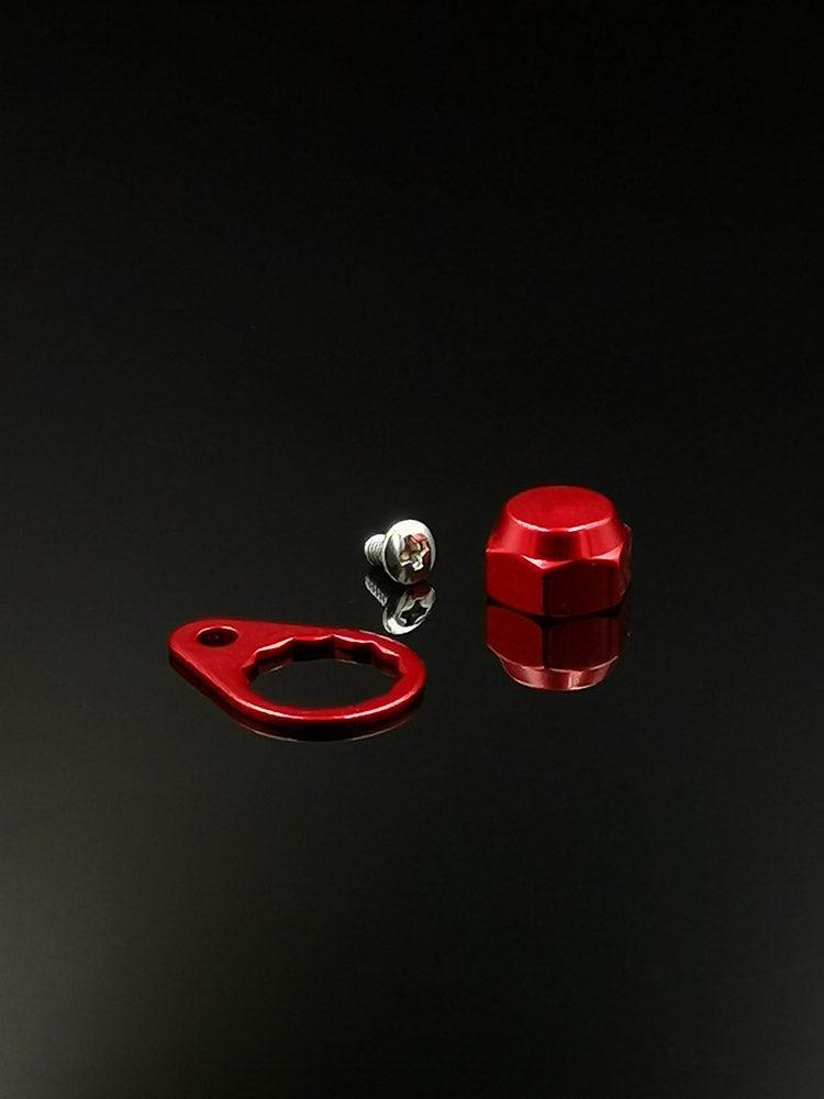 Ein Set mit drei RL-Angelrollentuning-Kontermuttern inkl. Platten | M7 | verschiedene Farben: eine silberne M7-Schraube, eine rote Sechskant-Kontermutter und eine rote Platte mit rundem Loch und länglichem Schlitz auf einer schwarz reflektierenden Oberfläche.