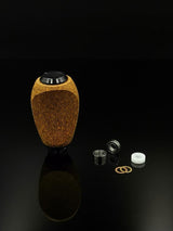 Der RL-TNG Kork Knob von RL-Angelrollentuning, ein strukturierter ovaler Knopf mit universeller Passform in mehreren Farben, steht aufrecht auf einer schwarzen Oberfläche neben Lagern, Unterlegscheiben und einem weißen Kunststoffring.