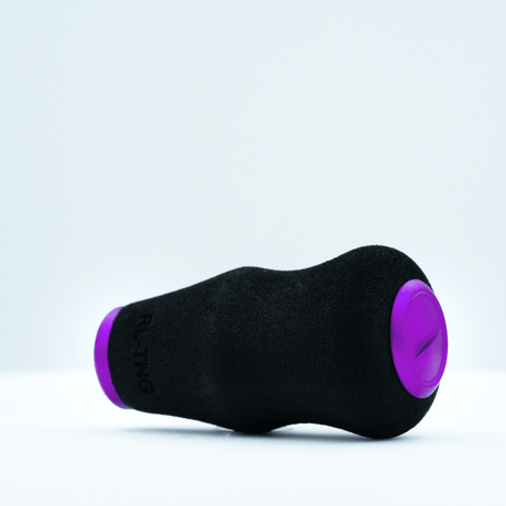 Der RL-TNG OCT 24 EVA-Knopf von RL-TNG verfügt über ein schwarz-violettes zylindrisches Design mit abgerundeten Enden und einer weichen, strukturierten EVA-Oberfläche für maximalen Halt, dargestellt auf der Seite liegend vor einem schlichten weißen Hintergrund.