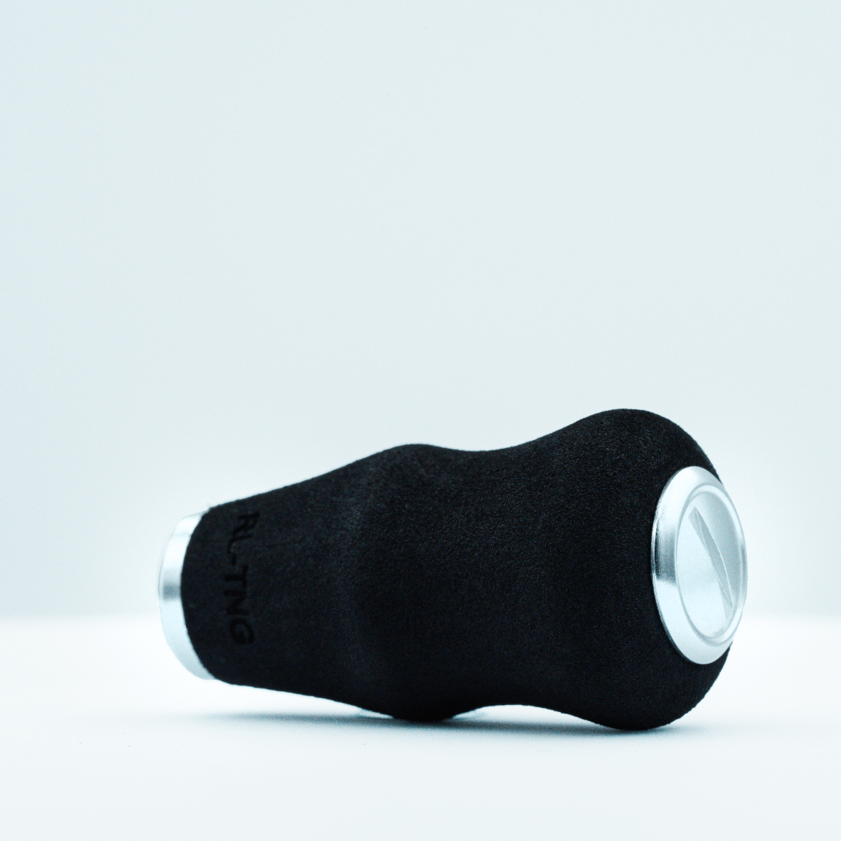 Der RL-TNG OCT 24 EVA-Knopf von RL-TNG, ein schwarzer Knauf mit silbernen Metallenden aus EVA-Material für maximalen Halt, ist auf der Seite liegend vor einem schlichten weißen Hintergrund abgebildet.