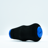 Ein schwarzer RL-TNG OCT 24 EVA-Knopf von RL-TNG mit blauen, runden Enden ruht auf weißem Untergrund. Er besteht aus weichem EVA-Material, trägt den partiellen „RLTNG“-Schriftzug und verspricht maximalen Grip bei ergonomischem Design.