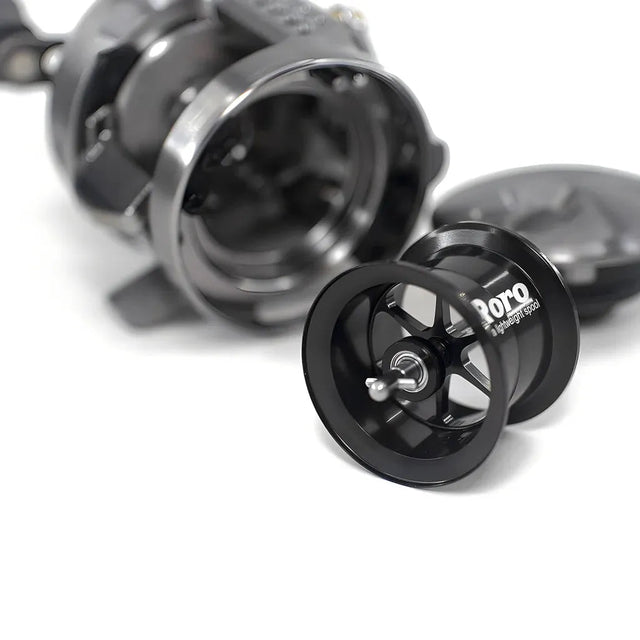 Eine Nahaufnahme einer zerlegten Roro Lure BFS Titanium Spule CQ25-MG | 23 Calcutta Conquest BFS in Schwarz, die die Hauptspule und die Innenteile auf einem weißen Hintergrund zeigt.