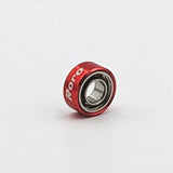 Ein kleines, rotes Roro Köder Roro BFS Keramik Kugellager mit "Roro" in weißer Schrift auf dem Gehäuse, fotografiert vor einem schlichten weißen Hintergrund.