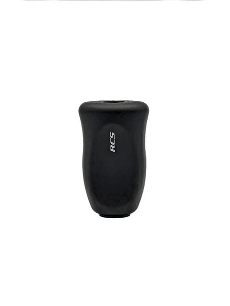 Ein schwarzer, zylindrischer SLP Works RCS i-Shape Korkknopf mit leicht gebogener Form und weißen, vertikal gedruckten RCS-Buchstaben vorne-perfekt für Daiwa Angeln Casting und Spinning Angelrollen, präsentiert auf weißem Hintergrund.