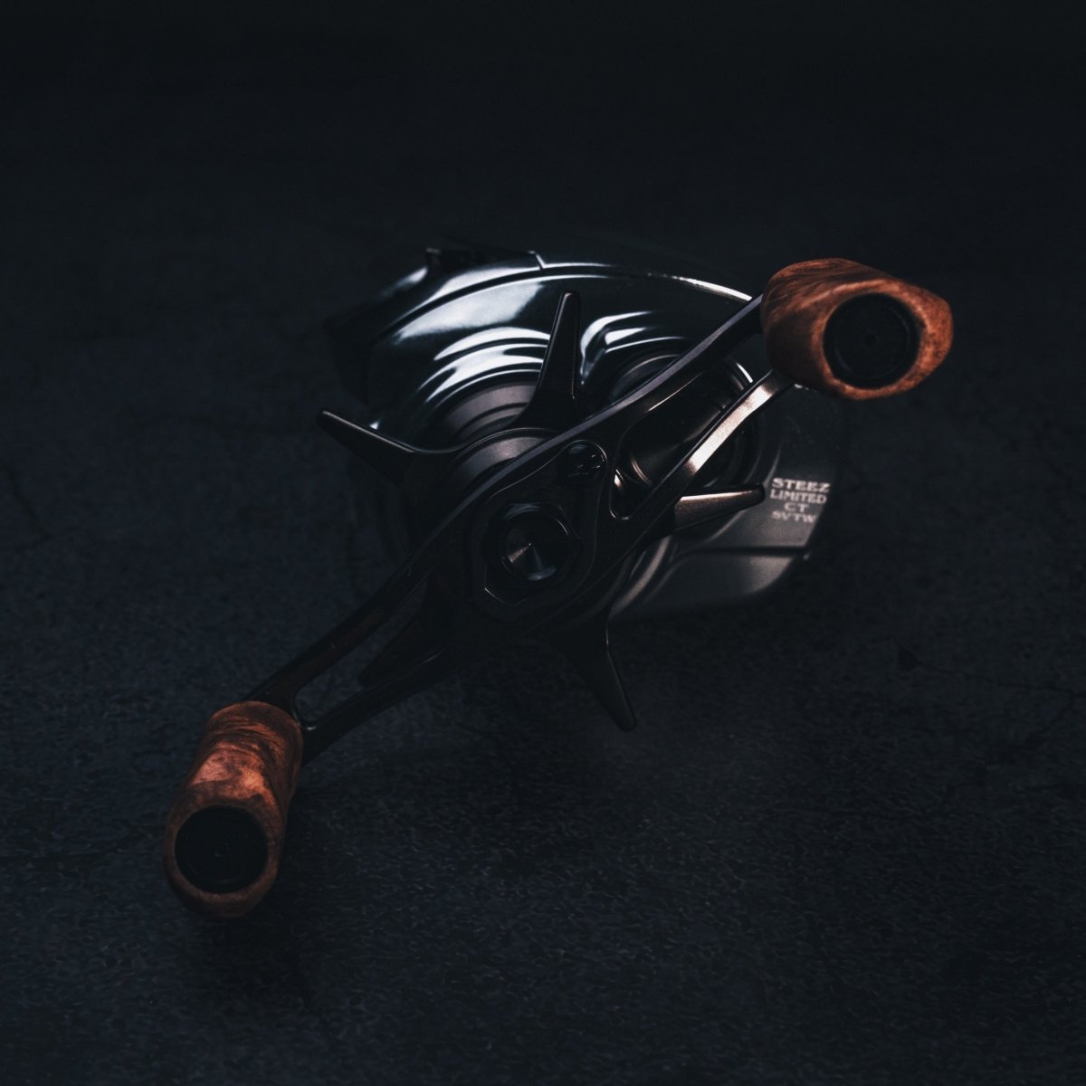 Nahaufnahme vom SLP Works i Shape Wood Knob Limited Edition – perfekt fürs Reel-Tuning! Der stilvolle Holzknauf glänzt mit einzigartiger Maserung und coolen Metall-Details vor dunklem Hintergrund. Mit dem richtigen Licht werden die schicken Akzente richtig in Szene gesetzt. Wenn du deinem Angelsetup ein Upgrade verpassen willst, geht’s nicht edler!.