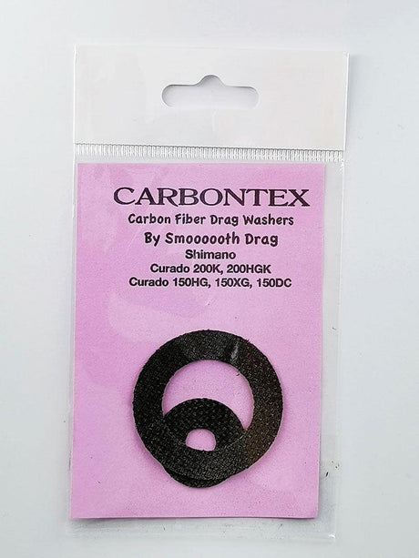 Ein Smoothdrag Bremsscheiben Carbontex-Pack für Shimano Baitcasterrollen enthält zwei schwarze runde Scheiben, die auf einem rosa Hintergrund in einer durchsichtigen Kunststoffverpackung abgebildet sind, und verspricht eine verbesserte Bremskraft für Ihre Angelrolle.