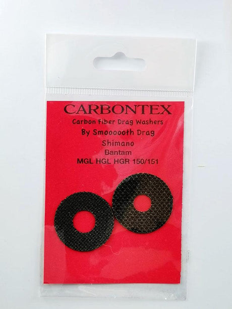 In einer Kunststoffverpackung befinden sich zwei schwarze Carbontex Bremsscheiben für Shimano Baitcasterrollen von Smoothdrag, die auf einer roten Karte mit der Aufschrift "Bremsscheiben Carbontex | Shimano Baitcasterrolle" für optimale Bremskraft sorgen.