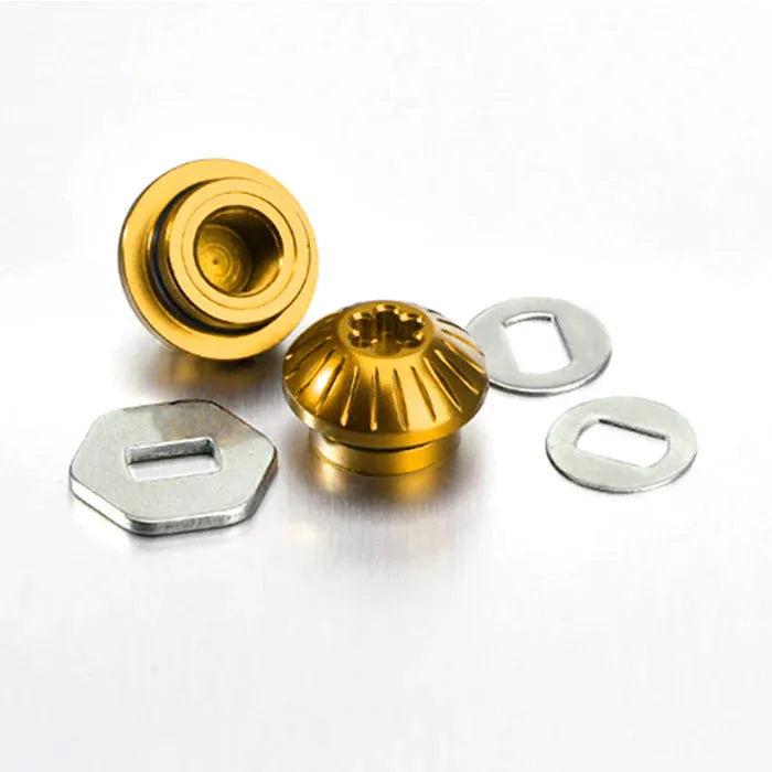 Zwei goldene Gomexus Aluminiummuttern werden mit zwei silbernen Metallscheiben und -platten kombiniert, passend zur Verwendung mit Angelrolle oder Gomexus Aluminium BDH-Griffen. Alle Artikel werden auf einer schlichten weißen Oberfläche präsentiert.