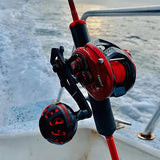 Eine Nahaufnahme des Gomexus Carbon Handle 75 mm mit 38 mm Power Knob (7x4mm) von Gomexus, befestigt an einer Angelrute auf einem Boot, mit Wasser und einem Teil der Bootsreling im Hintergrund.