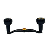 Ein schwarzer Gomexus Crank 110mm Handle mit 30 mm Sailor Power Knobs (8x5mm) für Baitcasterrolle, mit goldenen Akzenten, zwei zylindrischen Griffen und einem zentralen Befestigungspunkt auf weißem Hintergrund.